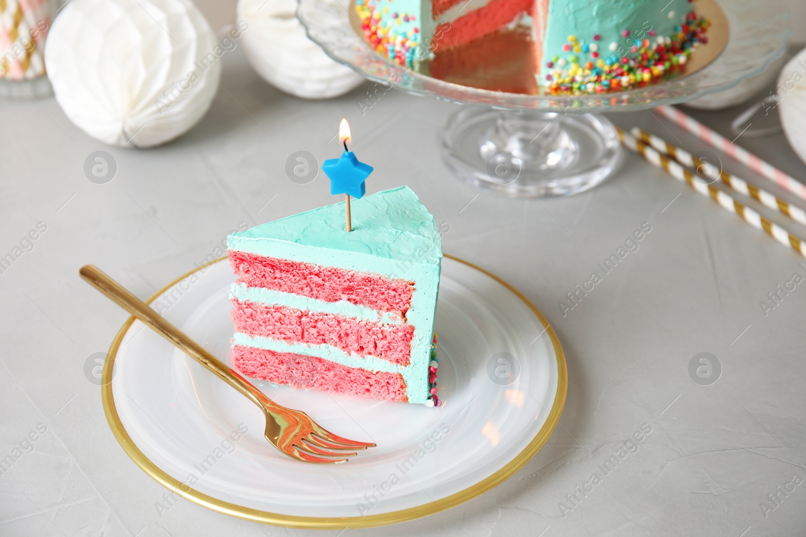 Photo of Slice of fresh delicious birthday cake with candle on table