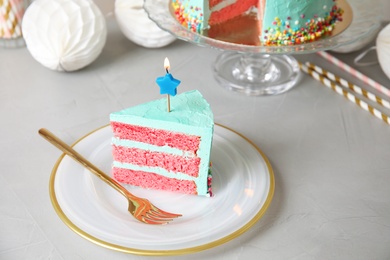 Slice of fresh delicious birthday cake with candle on table