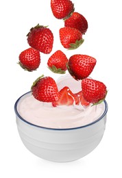 Delicious ripe strawberries falling into bowl with yogurt on white background