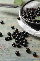 Photo of Ripe blackcurrants and leaves on wooden rustic table