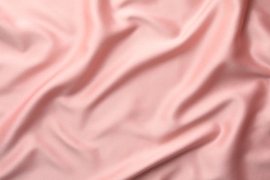 Photo of Crumpled pink silk fabric as background, top view