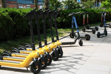 Many modern electric scooters on city street. Rental service