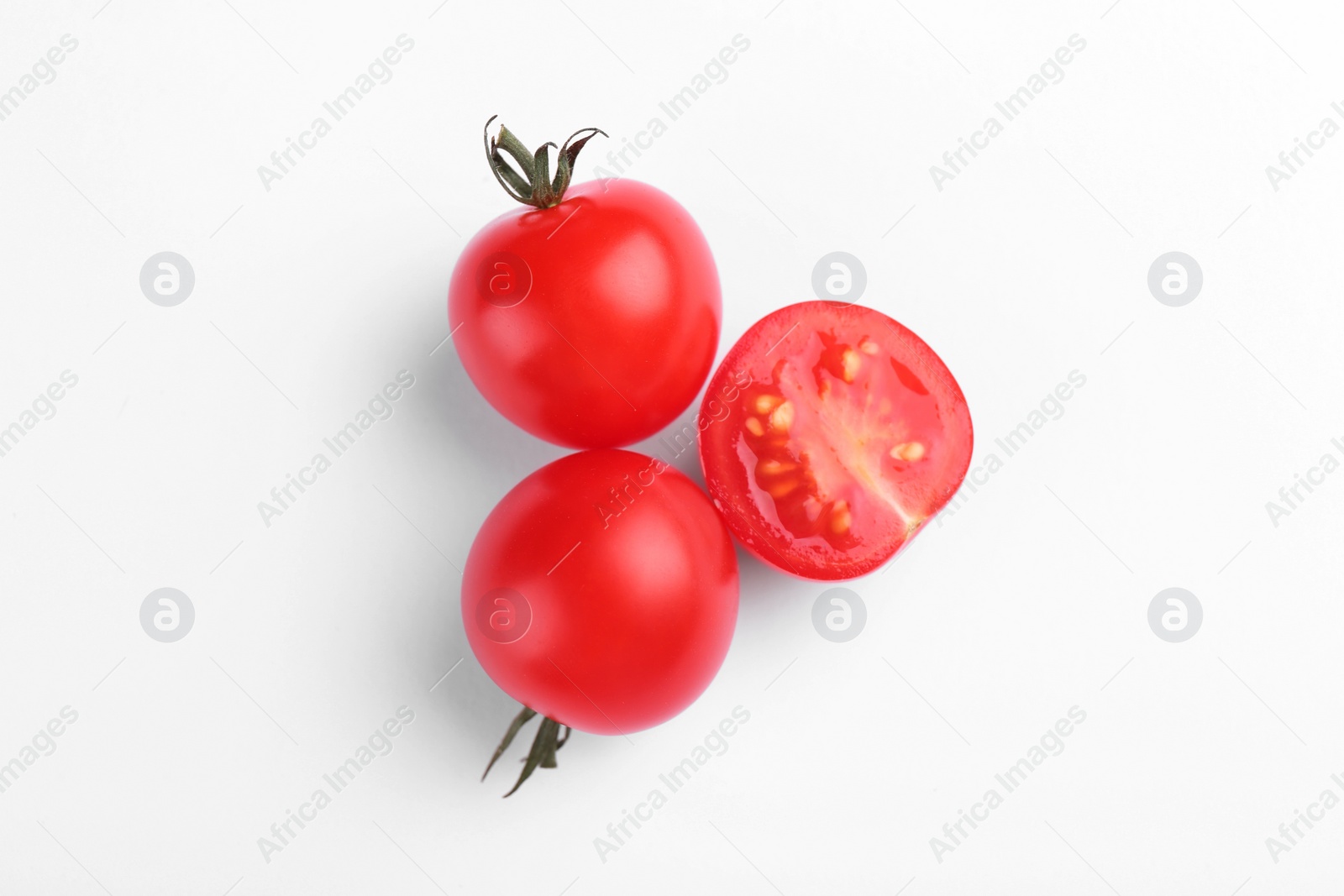 Photo of Whole and cut ripe tomatoes on white background, top view