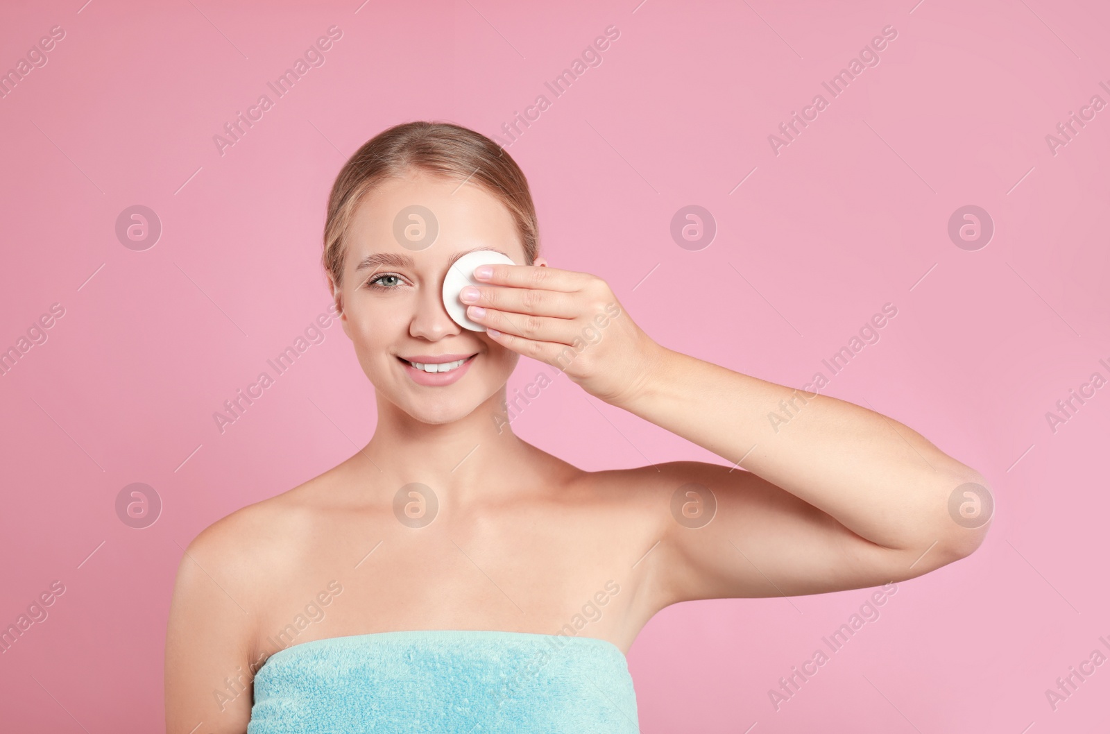 Photo of Beautiful young woman with cotton pad on pink background