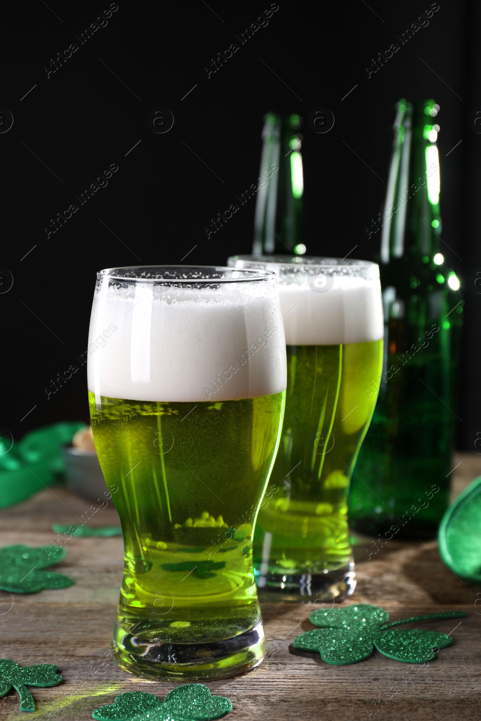 Photo of St. Patrick's day party. Green beer and decorative clover leaves on wooden table