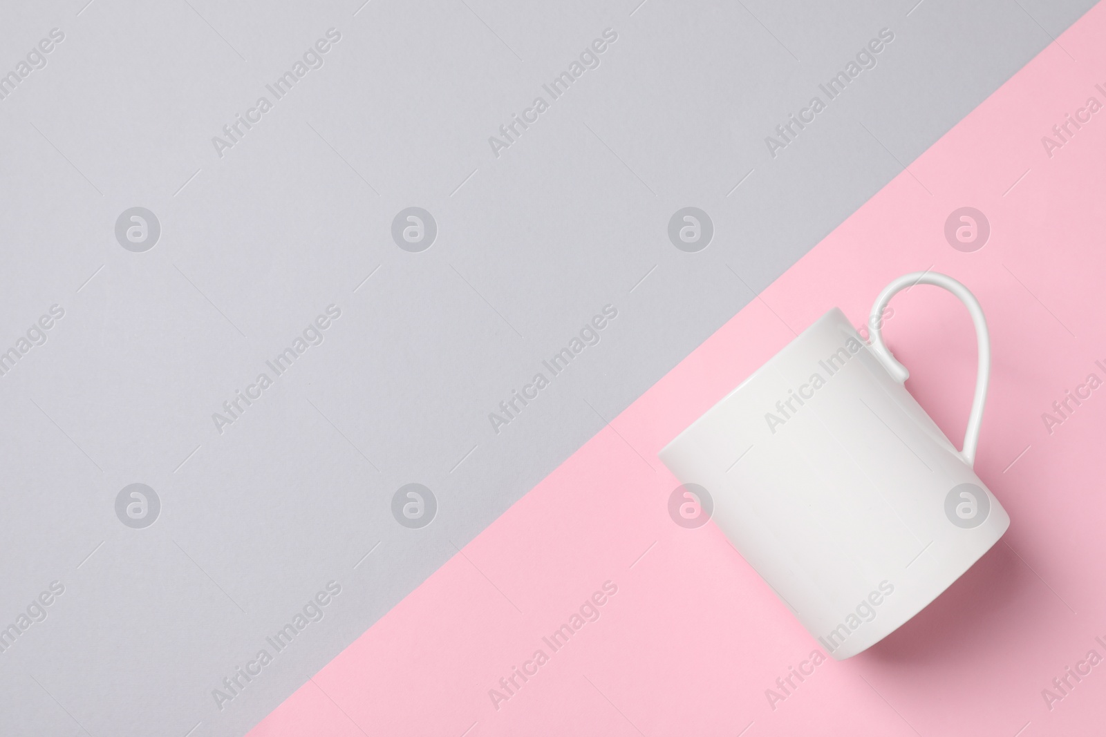 White ceramic mug on color background, top view and space for text Photo of White ceramic mug on color background, top view and space for text