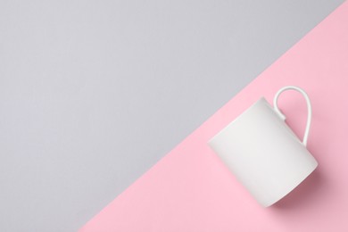 Photo of White ceramic mug on color background, top view and space for text