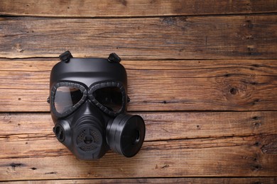 One gas mask on wooden background, top view. Space for text