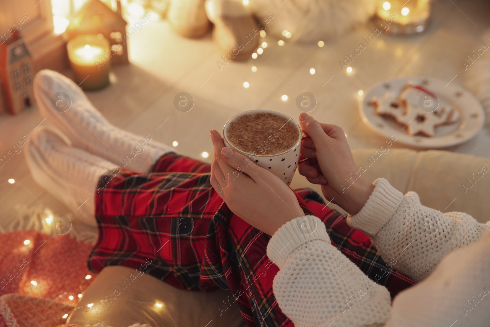 Photo of Woman with cup of hot drink at home, closeup. Christmas celebration