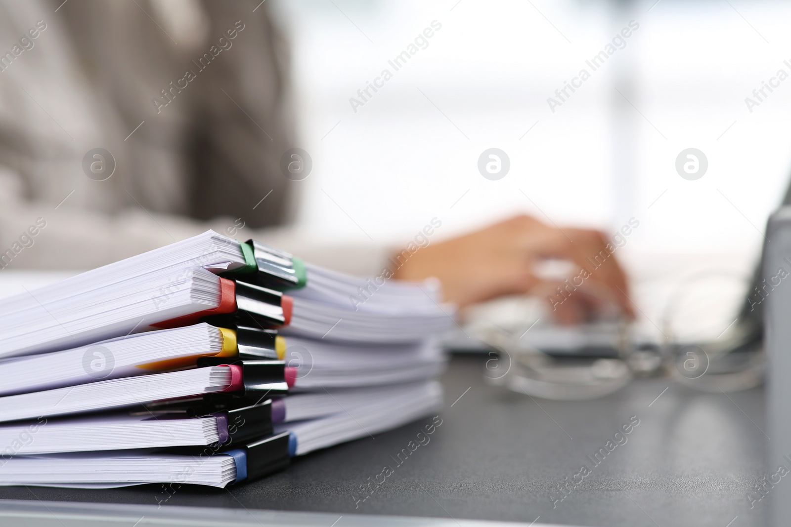 Photo of Businesswoman working with laptop at grey table in office, focus on documents. Space for text