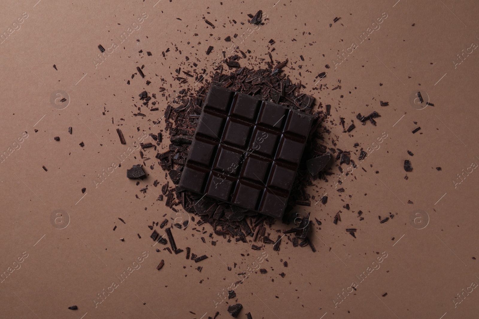 Photo of Tasty dark chocolate on brown background, flat lay