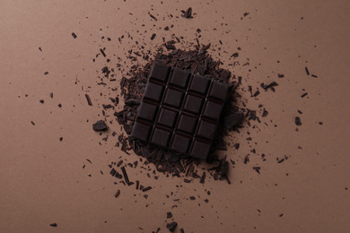 Photo of Tasty dark chocolate on brown background, flat lay