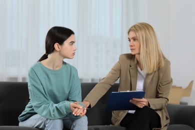 Photo of Psychologist working with teenage girl in office. Teenager problems