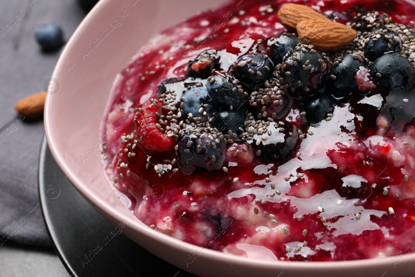 Photo of Tasty oatmeal porridge with toppings on table, closeup