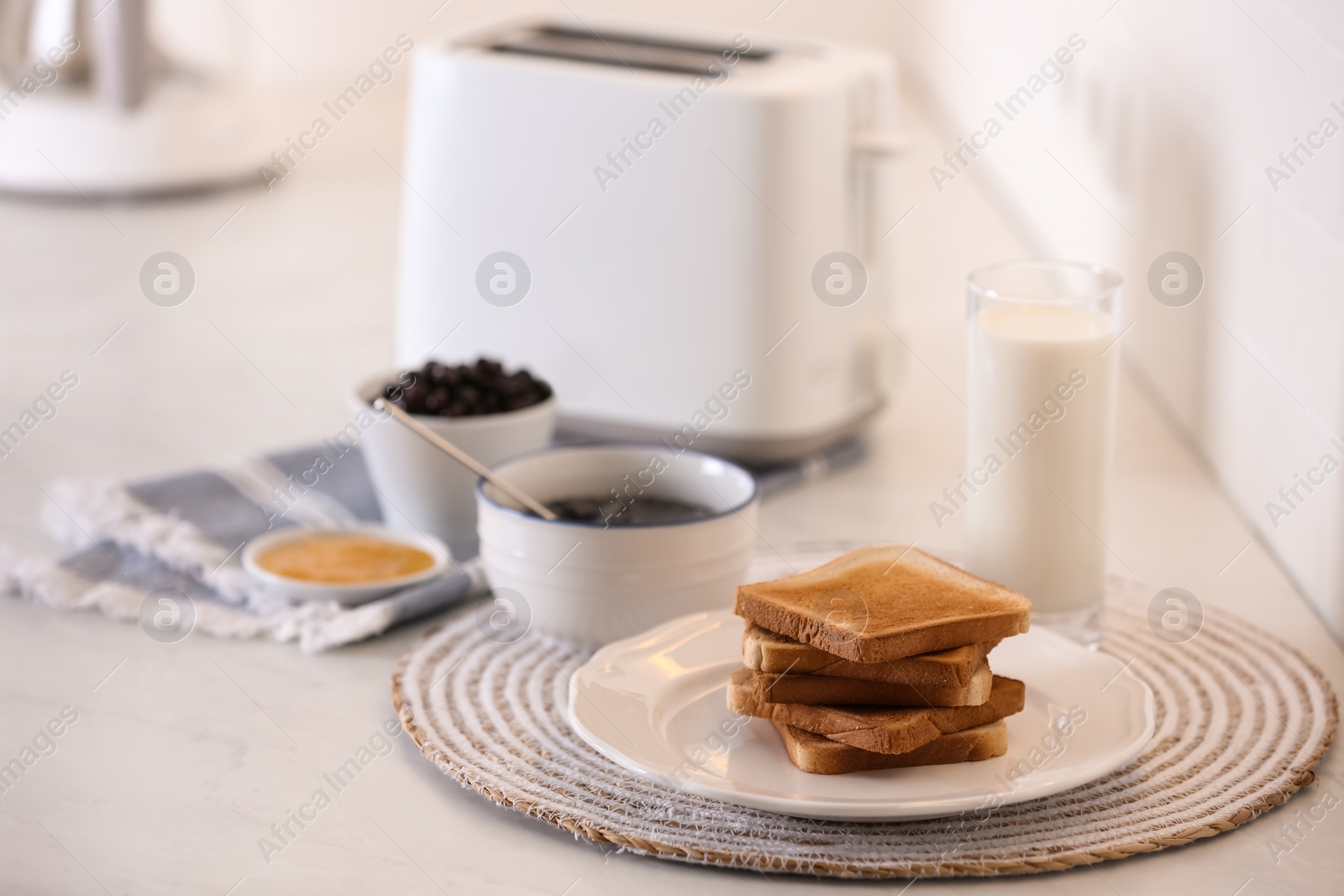 Photo of Modern toaster and delicious breakfast on table in kitchen