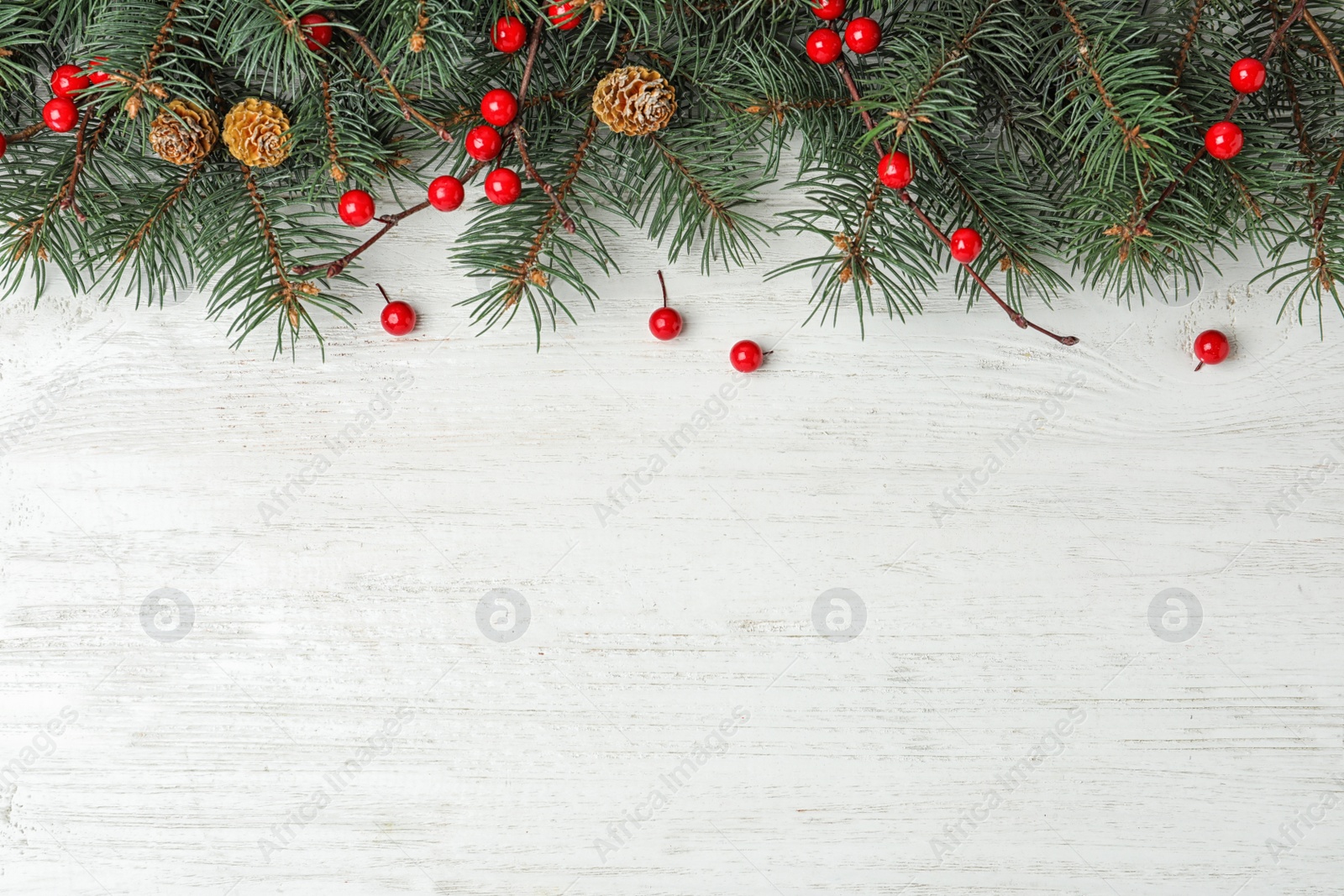 Photo of Flat lay composition with fir branches and berries on white wooden background, space for text. Winter holidays