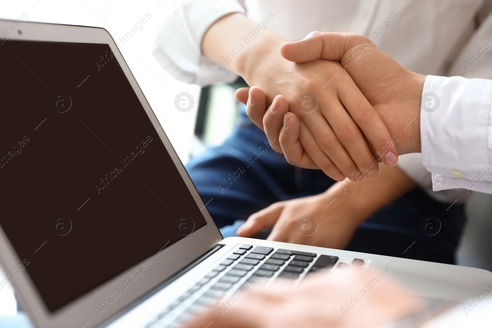 Photo of Business partners shaking hands after meeting, closeup