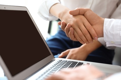 Photo of Business partners shaking hands after meeting, closeup