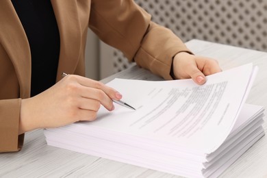 Woman signing document at wooden table, closeup