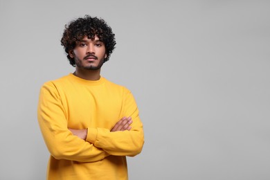 Handsome young man on light grey background, space for text