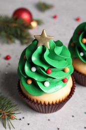 Photo of Christmas tree shaped cupcakes on light grey table