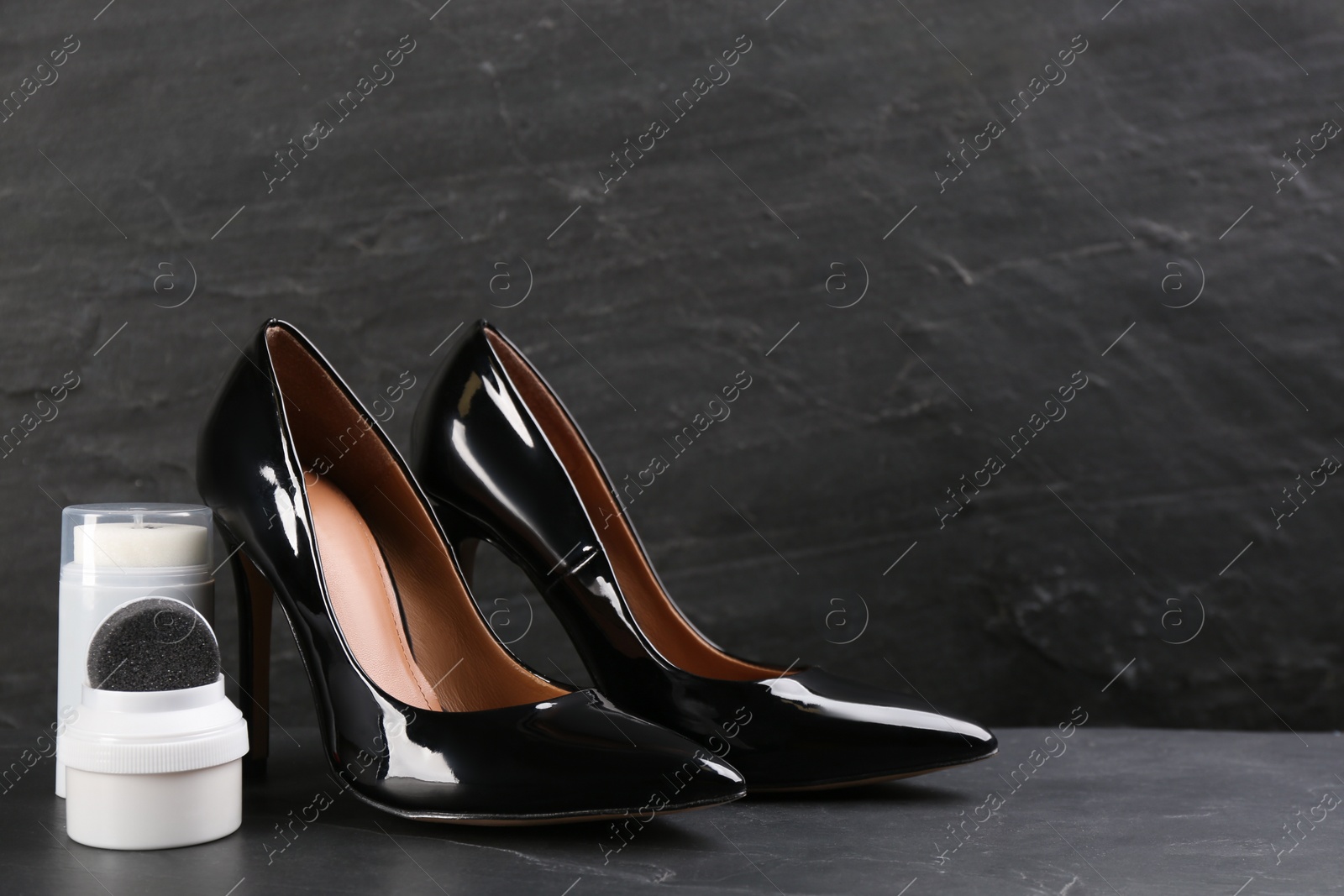 Photo of Shoe care accessories and footwear on black background. Space for text