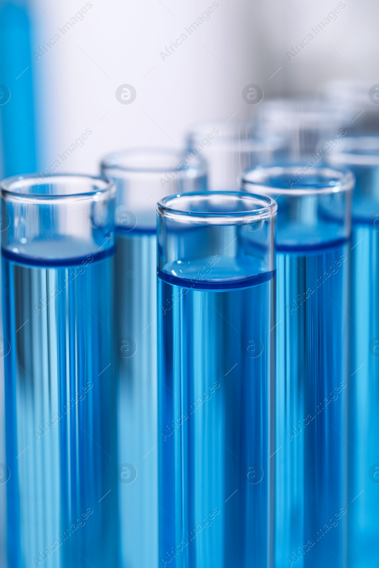 Photo of Test tubes with reagents on blurred background, closeup. Laboratory analysis