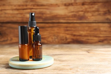 Photo of Bottles with oil on wooden table, space for text. Natural cosmetics