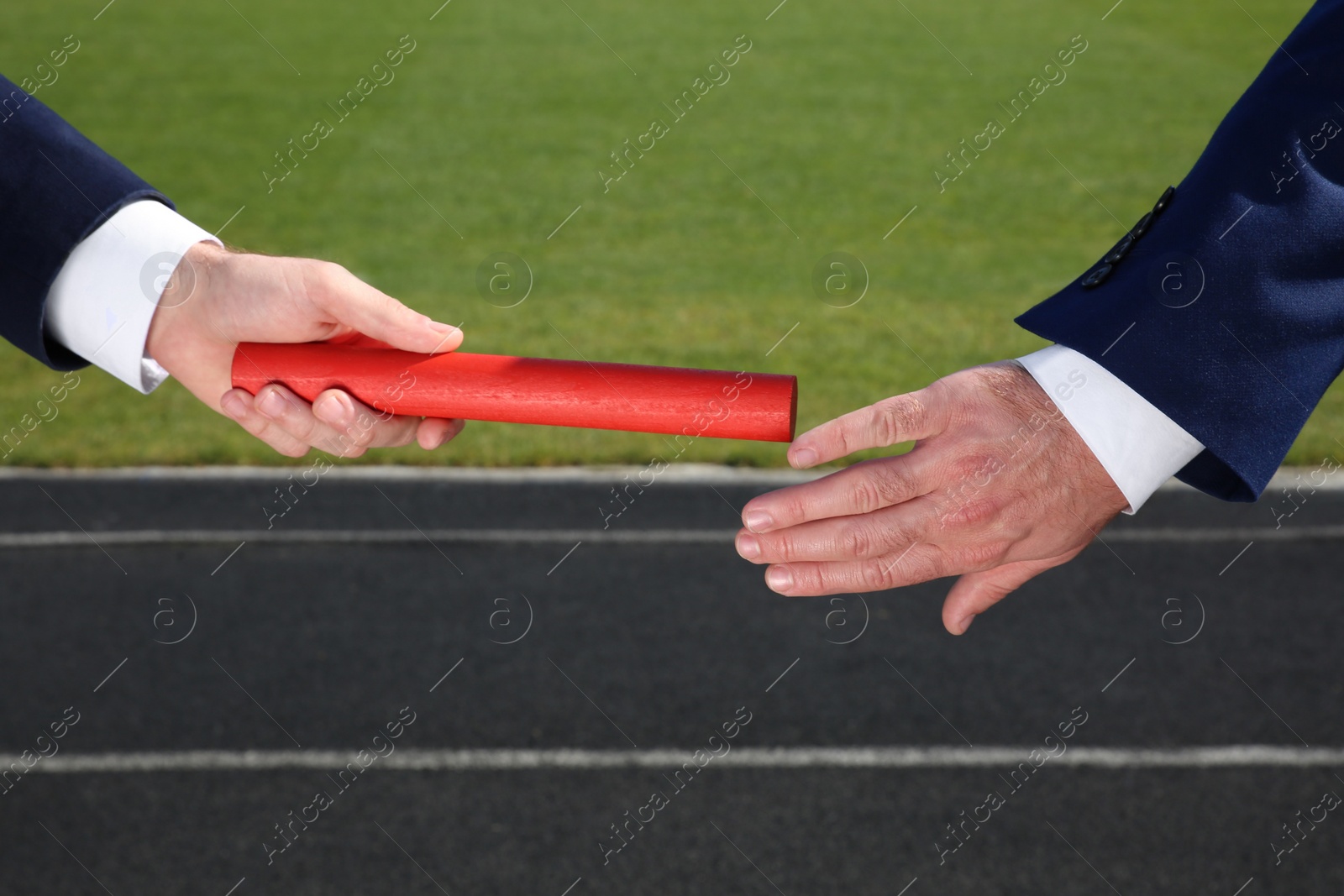 Photo of Businessman passing baton to his partner outdoors, closeup