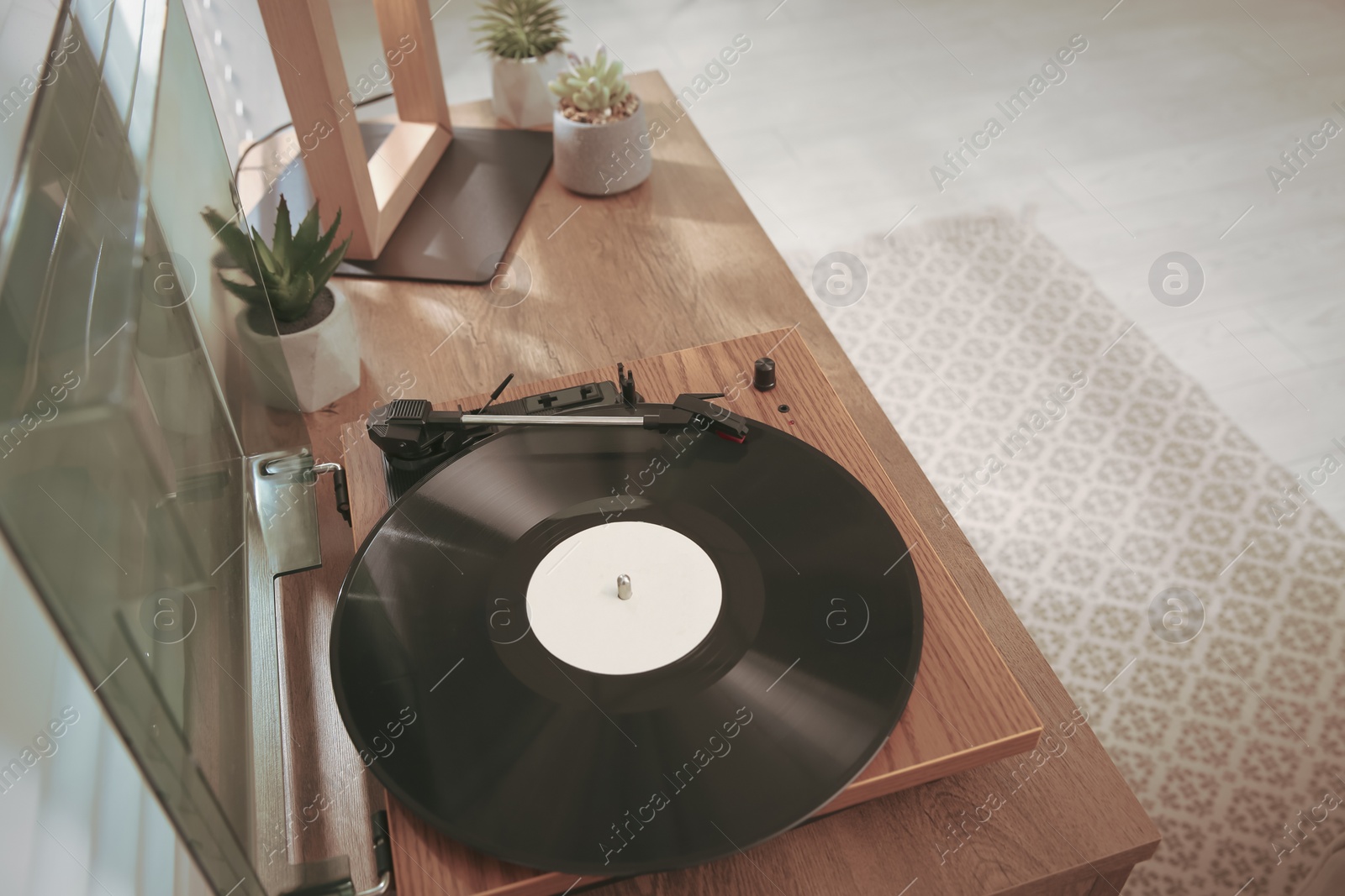Photo of Stylish turntable with vinyl record on wooden table indoors, above view