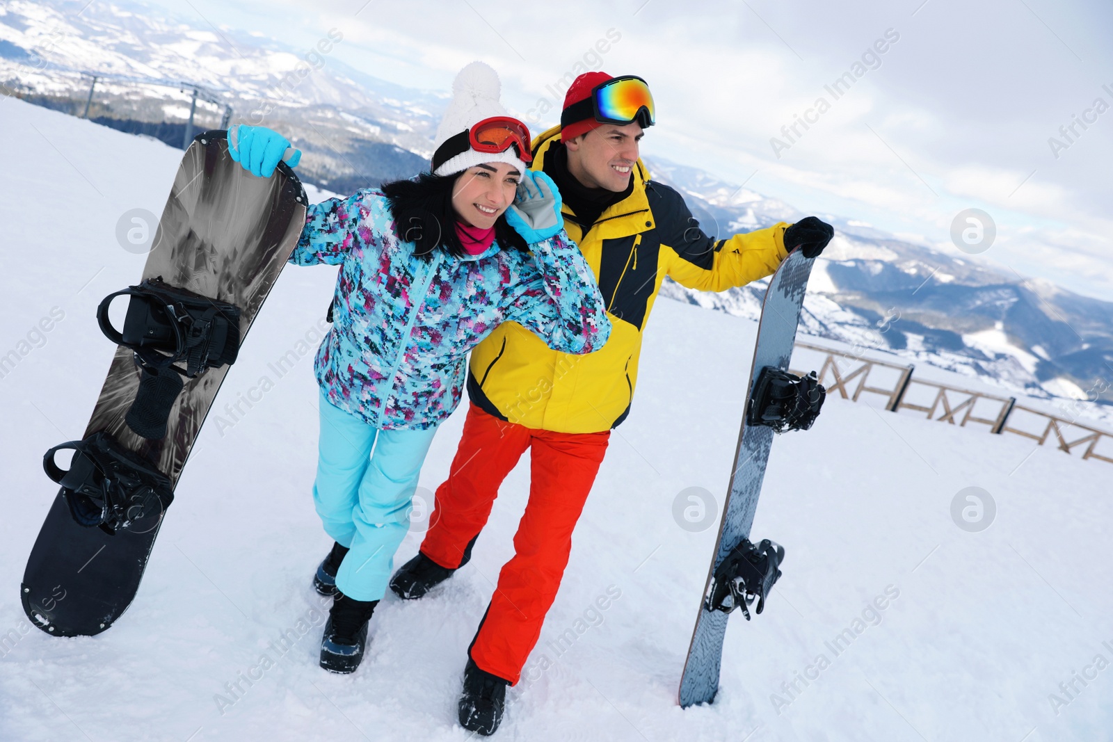 Photo of Lovely couple with snowboards on hill. Winter vacation