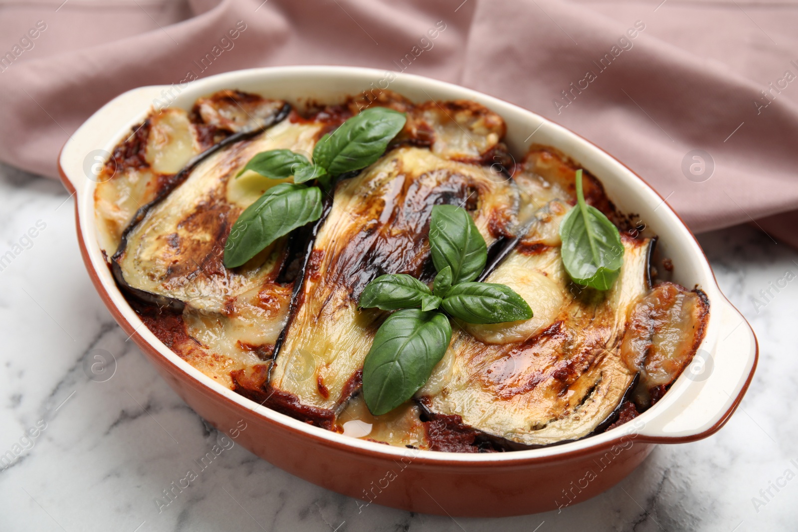 Photo of Delicious eggplant lasagna in baking dish on white marble table, closeup