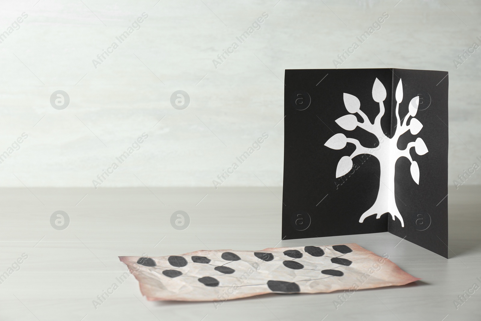 Photo of Card and paper with family tree templates on light wooden table. Space for text