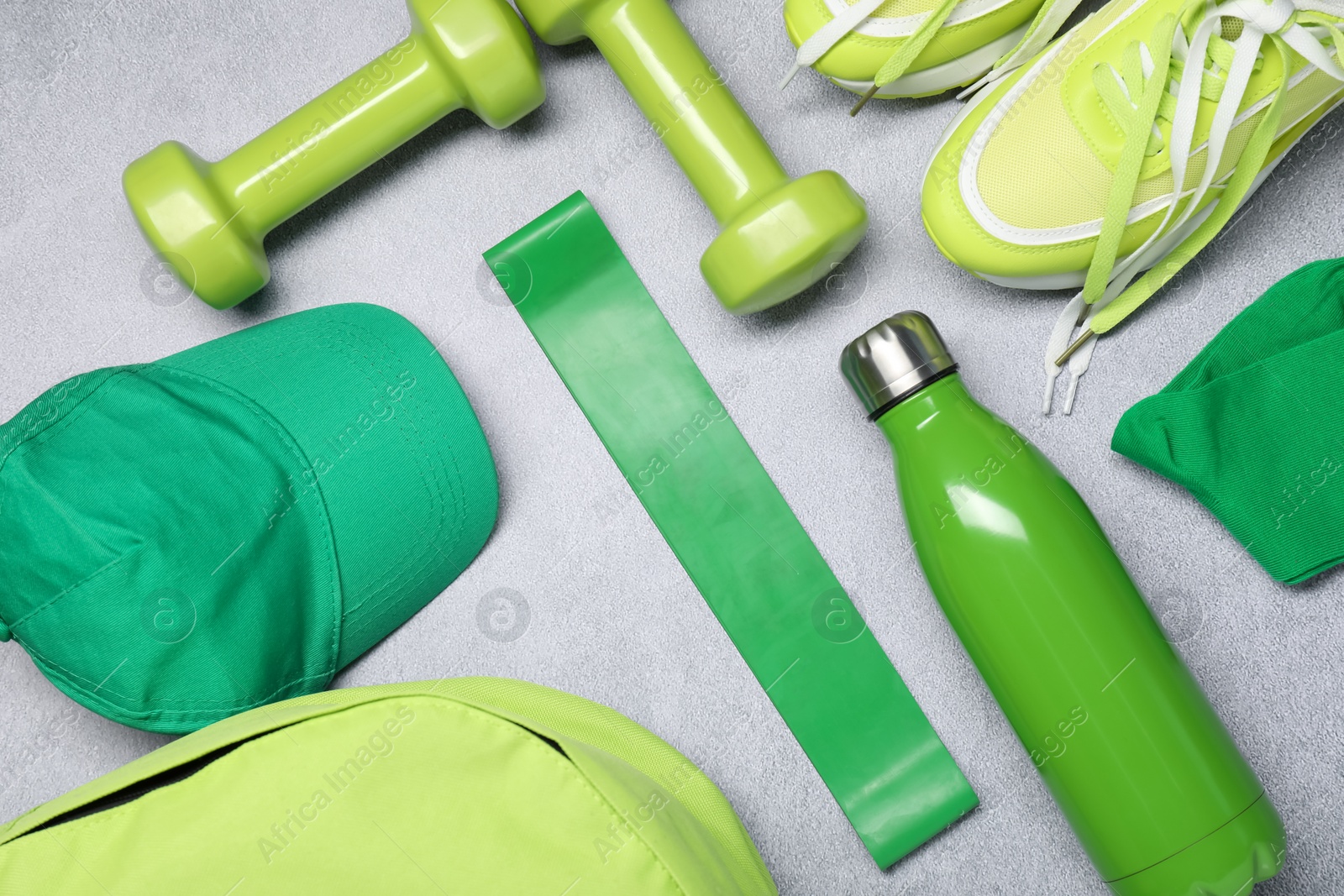 Photo of Different sports equipment on light grey table, flat lay