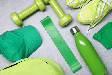 Different sports equipment on light grey table, flat lay