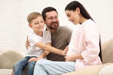 Happy pregnant woman spending time with her son and husband at home