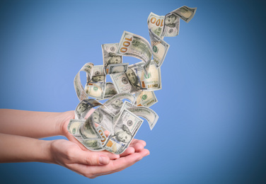 Woman with money on light blue background, closeup. Currency exchange