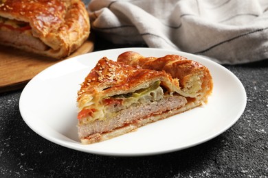 Photo of Piece of tasty homemade pie with filling on black table