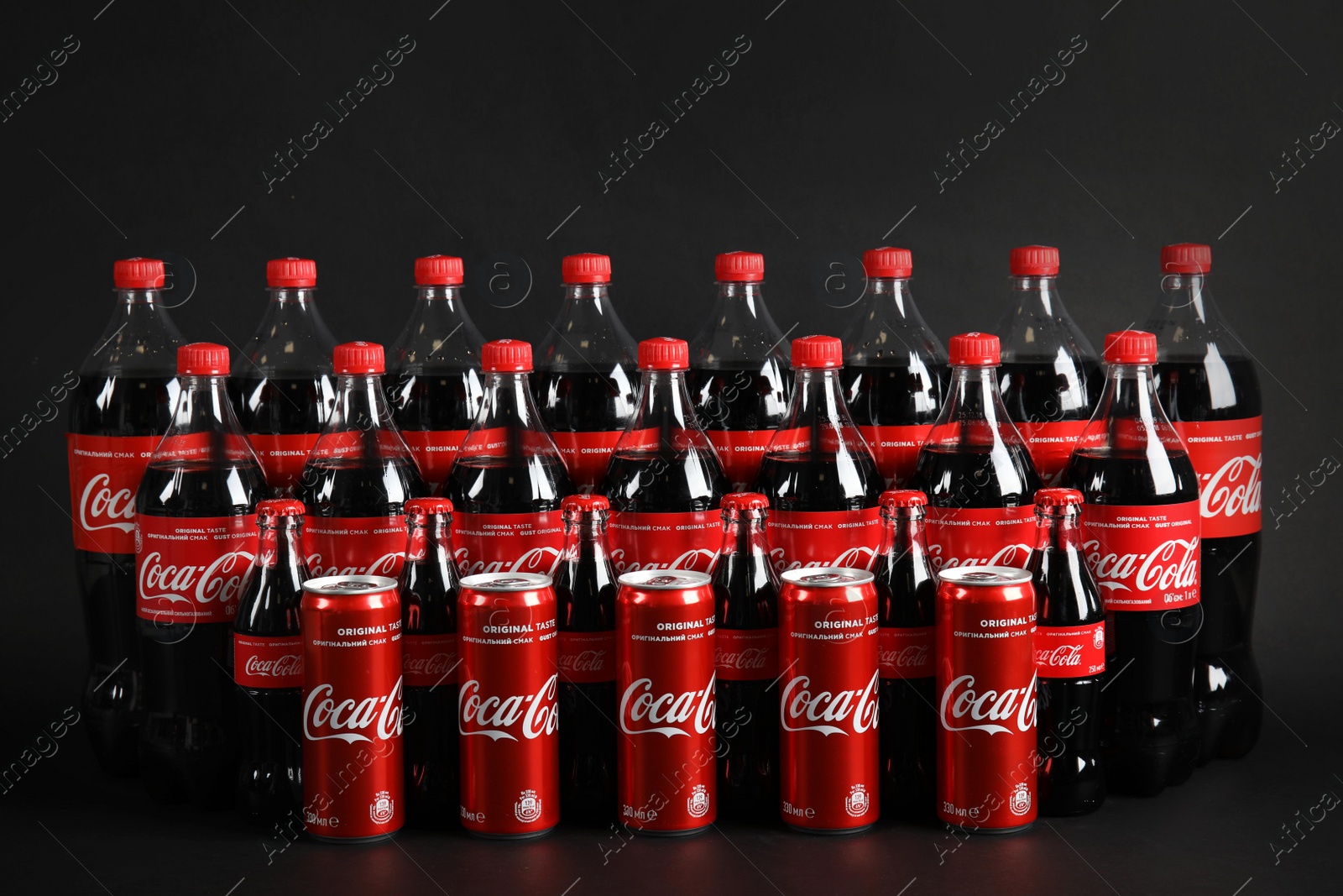 Photo of MYKOLAIV, UKRAINE - NOVEMBER 16, 2018: Bottles and cans with Coca-Cola on dark background