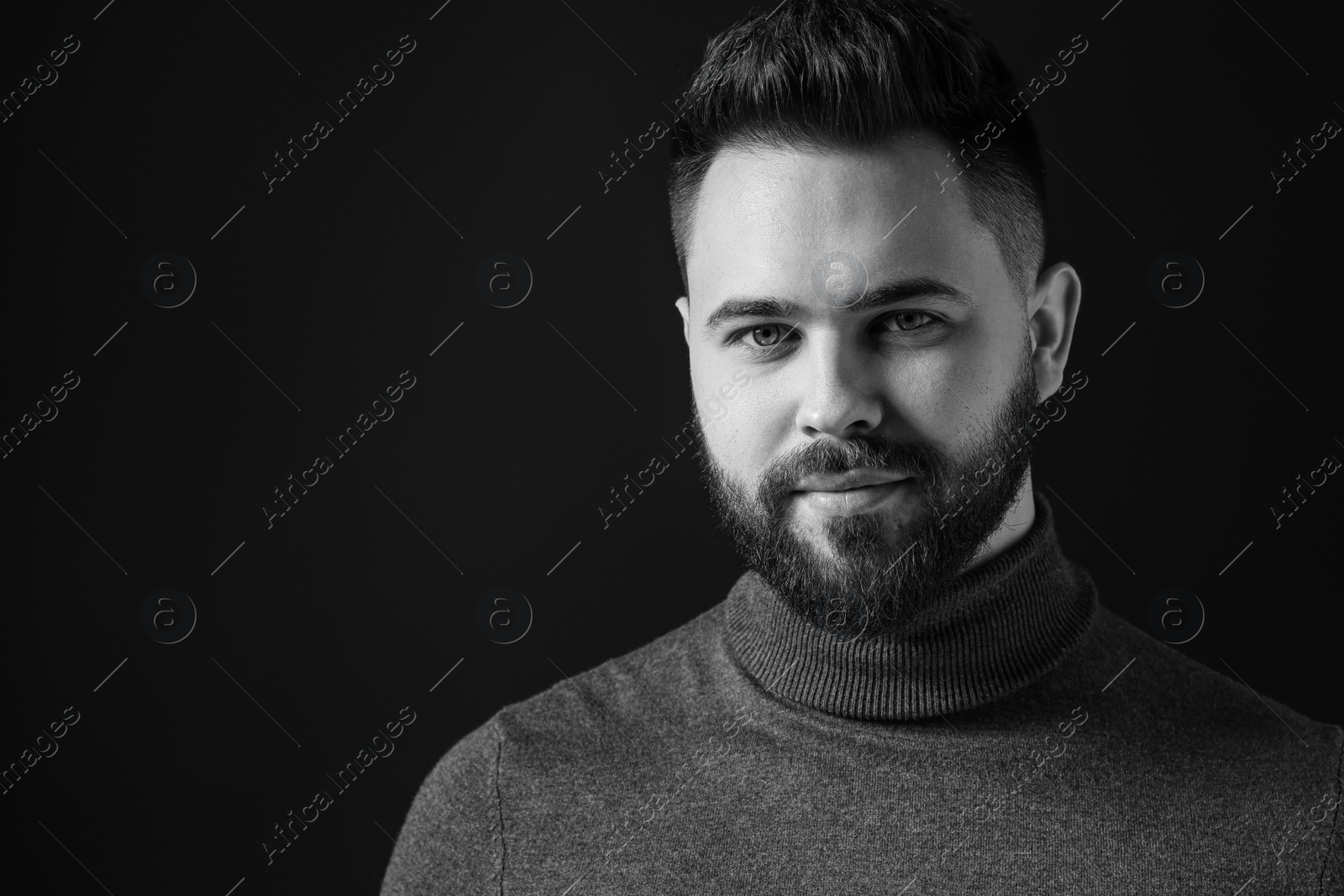 Photo of Portrait of handsome bearded man on dark background, space for text. Black and white effect