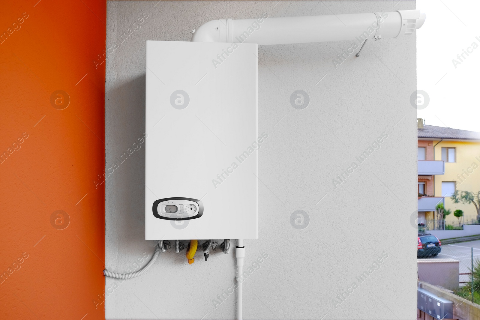 Photo of Gas boiler with temperature control indicator on white wall. Space for text