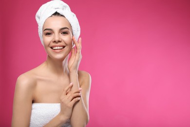 Photo of Happy young woman with towel on head against pink background, space for text. Washing hair