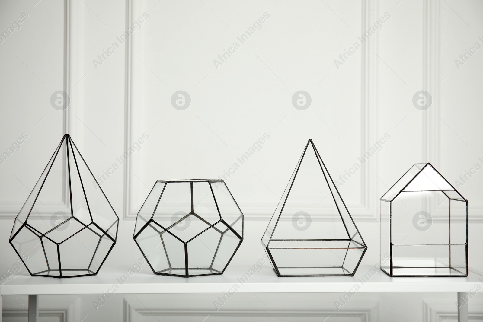Photo of Empty glass florarium vases on white table indoors