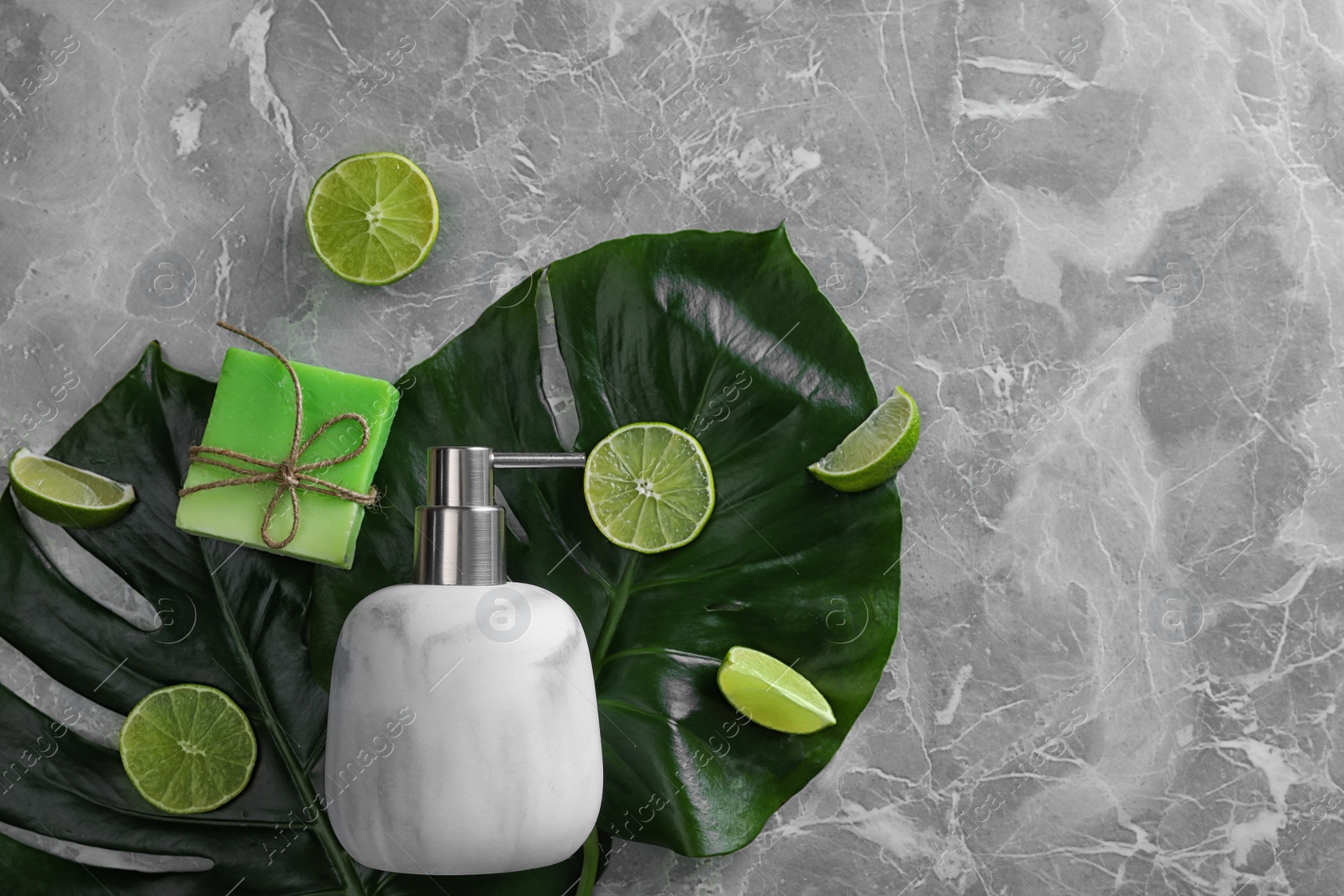 Photo of Flat lay composition with soap dispenser on grey marble background. Space for text