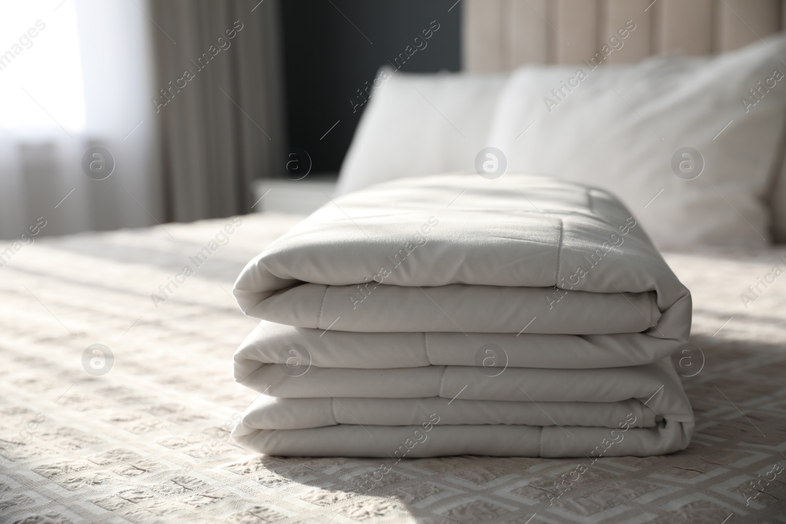 Photo of Folded clean blanket on bed in room