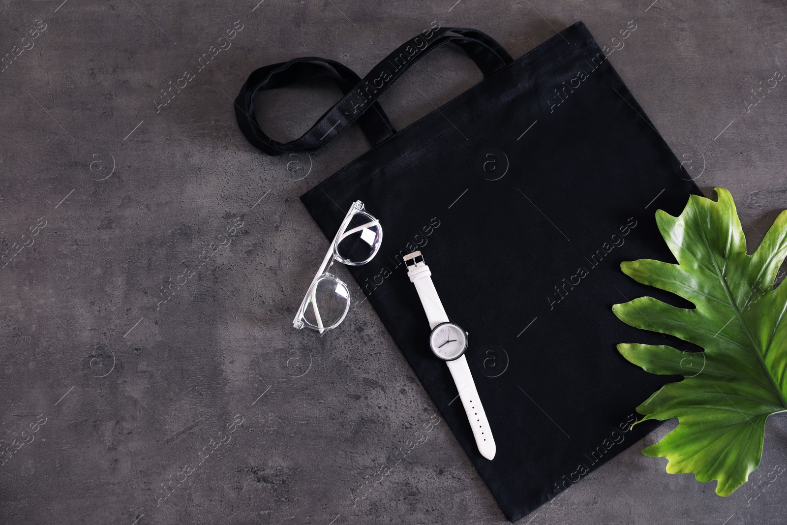 Photo of Flat lay composition with eco tote bag and accessories on grey background. Space for design