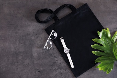 Photo of Flat lay composition with eco tote bag and accessories on grey background. Space for design