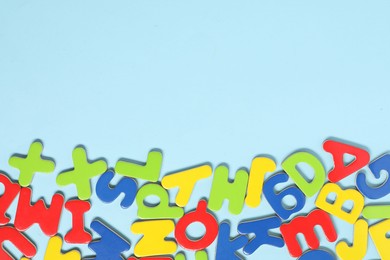 Photo of Learning alphabet. Magnetic letters on light blue background, flat lay. Space for text