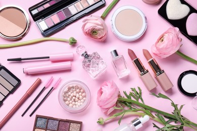 Photo of Flat lay composition with different makeup products and beautiful spring flowers on pink background