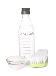 Photo of Eco friendly natural cleaners. Vinegar in bottle, brush and bowl of soda isolated on white